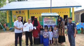 Koordinator TJSL PT Timah Tbk Unit Produksi Kundur saat menyerahkan bantuan kepada Pengelola Kelompok Bermain Rebung Layang di saksikan Sekcam Kundur Barat Sumiran. (Foto :  Humas PT Timah Tbk/KepriHeadline.id)