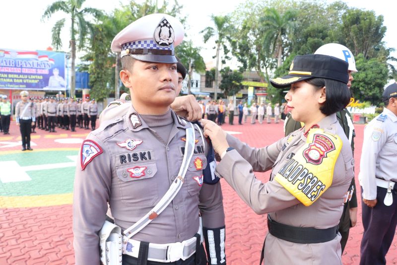 Wakapolres Karimun Kompol Petra menyematkan pita Ops Keselamatan kepada salah satu personil Satlantas Polrss Karimun, Selasa (7/2/2023). (Foto : Humas Polres/KepriHeadline.id)