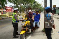 Petugas Satlantas Polres Karimun menegur salah satu pengendara sepeda motor yang tidak menggunakan helm. Foto: dok KepriHeadline.id