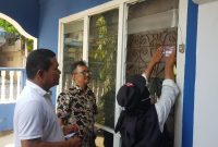 Petugas Pantarlih menempelkan tanda Coklit di rumah waega yang baru selesai pendataan. Foto: ist/kepriheadline.id
