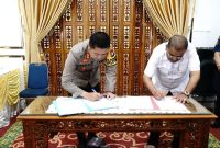Kapolres Karimun AKBP Ryky W. Muharam (Kiri) bersama Bupati Karimun Aunur Rafiq (Kanan) menandatangani nota kesepakatan terkaut aktivitas pelabuhan bongkar muat. Foto: kepriheadline.id