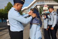 Kakanim Kelas II TPI Tanjungbalai Karimun Zulmanur Arif menyematkan tanda Hand Badge kepada ketua TIM Pokja dalam Apel Pengukuhan Tim Pokja, Selasa (8/3/2023). (FOTO: Dokumen Imigrasi).