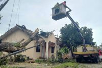 Warga dibantu petugas melakukan evakuasi terhadap reruntuhan pohon. (Foto: kepriheadline.id)