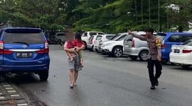 Seorang wanita dengan kepala bersimbah darah jalan kaki sambil mengendong anak. (foto: kepriheadline.id)