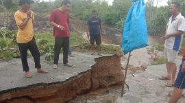 Warga sekitar menutup akses jalan Pantai Timun yang amblas akibat hujan deras, Jumat (4/3/2023) malam. (FOTO: ISTIMEWA/KEPRIHEADLINE.ID)