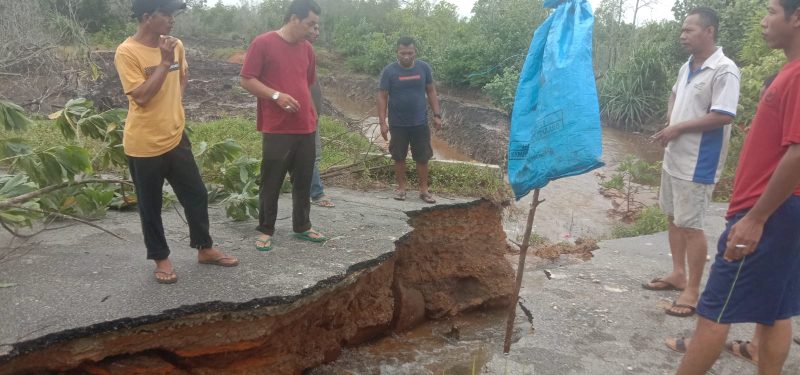 Warga sekitar menutup akses jalan Pantai Timun yang amblas akibat hujan deras, Jumat (4/3/2023) malam. (FOTO: ISTIMEWA/KEPRIHEADLINE.ID)