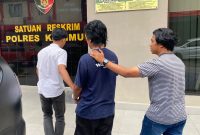 Agen Chip Higgs Domino asal Batam berinisial JA (46) digiring saat hendak menjalani pemeriksaan di Mapolres Karimun. (Foto: Humas Polres Karimun)