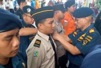 Kepala KSOP Kelas I Tanjungbalai Karimun Jon Kenedy menyematkan pita tanda operasi kepada perwakilan petugas gabungan angkutan Lebaran Idul Fitri. (Foto: Kepriheadline.id)