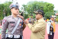 Bupati Karimun Aunur Rafiq menyematkan pin tanda operasi kepada perwakilan petugas Ops Ketupat 2023. (Foto: Humas Polres Karimun)