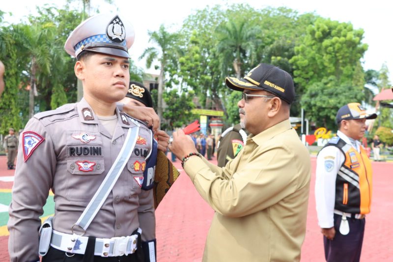 Bupati Karimun Aunur Rafiq menyematkan pin tanda operasi kepada perwakilan petugas Ops Ketupat 2023. (Foto: Humas Polres Karimun)