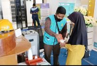 Salah satu petugas PLN memberikan layanan kepada pemudik di Posko Mudik BUMN 2023 di Pelabuhan Domestik Karimun. (Foto: Kepriheadline.id)