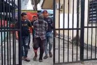 Pelaku A dengan kondisi kaki pincang digiring satreskrim Polres Karimun usai tiba di Pelabuhan Domestik Karimun. Foto: Istimewa