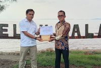 Koordinator PPM PT Timah Unit Kundur Eka Budhy Susanto saat menyerahkan bantuan perbaikan Tembok yang runtuh disekitar Pantai Teluk Dalam, kepada Kepala Desa Kundur Marhalim. (Foto: Humas PT Timah)