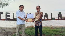 Koordinator PPM PT Timah Unit Kundur Eka Budhy Susanto saat menyerahkan bantuan perbaikan Tembok yang runtuh disekitar Pantai Teluk Dalam, kepada Kepala Desa Kundur Marhalim. (Foto: Humas PT Timah)