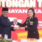 Bupati Karimun Aunur Rafiq menyerahkan potongan tumpeng kepada Wakapolres Karimun Kompol Petra Tumengkol.dalam kegiatan syukuran Hari Bhayangkara ke-77. Foto: Istimewa
