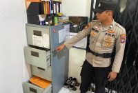 Petugas Polsek Kundur menunjukkan lokasi laci tempat pelaku pencurian mengambil uang. Foto: Dokumen Polisi