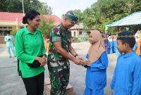 Dansatgas TMMD ke-117 Letkol Inf Bidianto Damanik menyerahkan makanan sehat kepada pelajar. Foto: Dokumen Satgas TMMD
