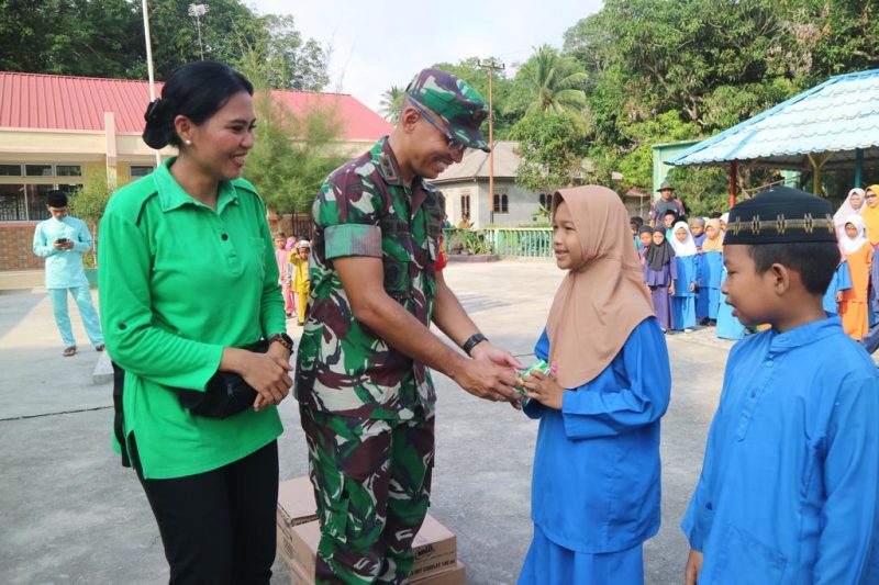Dansatgas TMMD ke-117 Letkol Inf Bidianto Damanik menyerahkan makanan sehat kepada pelajar. Foto: Dokumen Satgas TMMD