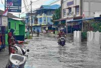 Warga melintas di kawasan Pelipit yang terdampak banjir setelah diguyur hujan pada Selasa siang. Foto: rr