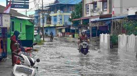 Warga melintas di kawasan Pelipit yang terdampak banjir setelah diguyur hujan pada Selasa siang. Foto: rr