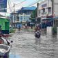 Warga melintas di kawasan Pelipit yang terdampak banjir setelah diguyur hujan pada Selasa siang. Foto: rr