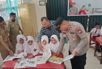 Kapolsek Buru Iptu Junaidi melaksanakan pendistribusian buku ke sekolah di Kecamatan Buru. Foto: istimewa