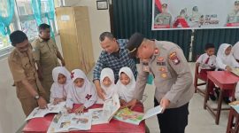 Kapolsek Buru Iptu Junaidi melaksanakan pendistribusian buku ke sekolah di Kecamatan Buru. Foto: istimewa