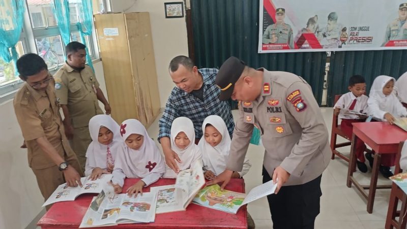 Kapolsek Buru Iptu Junaidi melaksanakan pendistribusian buku ke sekolah di Kecamatan Buru. Foto: istimewa