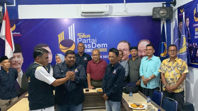 Pemasangan seragam kepada dua kader baru Partai Nasdem oleh Ketua DPD Partai Nasdem Yusrizal. Foto: Istimewa