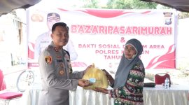 Kapolres Karimun AKBP Fadli Agus menyerahkan sembako murah kepada masyarakat Telaga Mas. Foto: Humas Polres Karimun