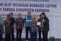 Anggota Komisi VII DPR RI Asman Abnur menyerahkan bantuan program AML ke masyarakat. Foto: KepriHeadline.id