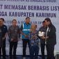 Anggota Komisi VII DPR RI Asman Abnur menyerahkan bantuan program AML ke masyarakat. Foto: KepriHeadline.id
