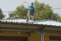 Petugas PLN melakukan perbaikan jaringan listrik di rumah salah satu warga terdampak angin puting beliung. (Foto: istimewa/kepriheadline.id)