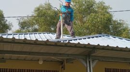 Petugas PLN melakukan perbaikan jaringan listrik di rumah salah satu warga terdampak angin puting beliung. (Foto: istimewa/kepriheadline.id)