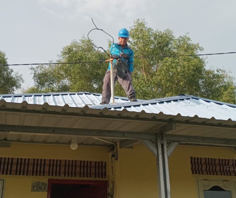 Petugas PLN melakukan perbaikan jaringan listrik di rumah salah satu warga terdampak angin puting beliung. (Foto: istimewa/kepriheadline.id)