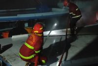 Petugas Pemadam Kebakaran Karimun melakukan upaya pemadaman api yang membakar satu unit kapal nelayan di Pelabuhan Kamkong, Kecamatan Meral. (FOTO: Tangkapan Layar Video Damkar Karimun)