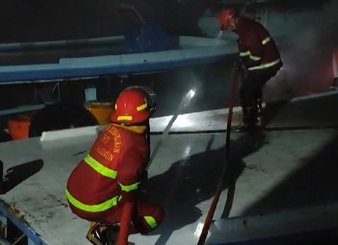 Petugas Pemadam Kebakaran Karimun melakukan upaya pemadaman api yang membakar satu unit kapal nelayan di Pelabuhan Kamkong, Kecamatan Meral. (FOTO: Tangkapan Layar Video Damkar Karimun)