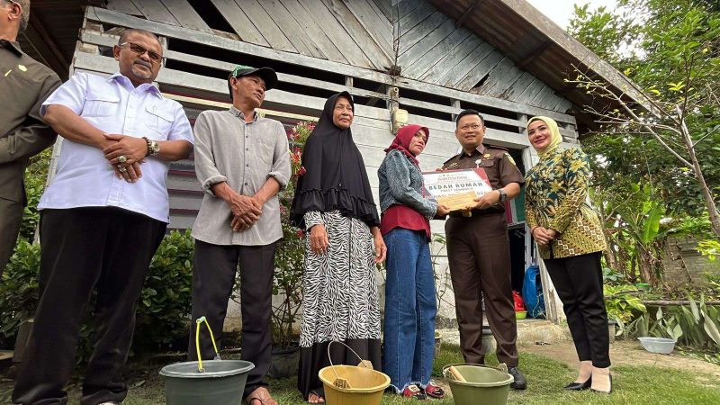 Kajari Karimun Priyambudi menyerahkan bantuan uang tunai kepada salah satu penerima bantuan rehab RTLH. (Foto: ricky/kepriheadline.id)