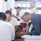 Seorang warga menemani anaknya mengikuti khitanan massal Bulan Bakti PT Timah. (Foto: Dokumen PT Timah)