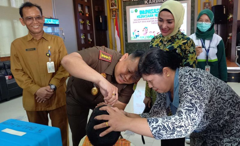 Kajari Karimun Priyambudi dengan didampingi Istri melakukan vaksinasi polio kepada salah satu peserta. (Foto: ricky/kepriheadline.id)