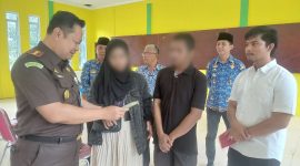Kajari Karimun Priyambudi menyerahkan buku nikah kepada korban KDRT, setelah perkaranya selesai melalui Restorative Justice. (Foto: ricky/kepriheadline.id)