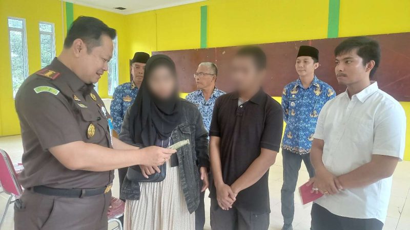 Kajari Karimun Priyambudi menyerahkan buku nikah kepada korban KDRT, setelah perkaranya selesai melalui Restorative Justice. (Foto: ricky/kepriheadline.id)