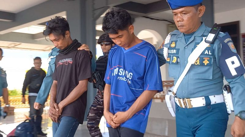 Dua Tekong Boat Pancung pembawa belasan PMI asal Malaysia digiring Petugas Lanal Karimun saat konferensi pers oleh Lanal TBK, Selasa, 6 Agustus 2024. (Foto: ricky/kepriheadline.id)