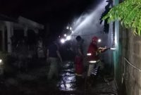 Petugas Damkar bersama Kepolisian melakukan upaya pemadaman terhadap rumah semi permanen yang terbakar, Rabu malam.