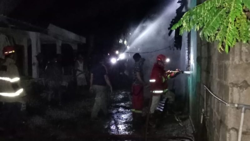 Petugas Damkar bersama Kepolisian melakukan upaya pemadaman terhadap rumah semi permanen yang terbakar, Rabu malam.