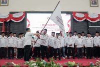 Ketua DPW IKM Kepri Momon Faulana Adinata menyerahkan bendera pataka kepada Ketua DPD IKM Kabupaten Karimun Devanan Syam. (Foto: Istimewa)