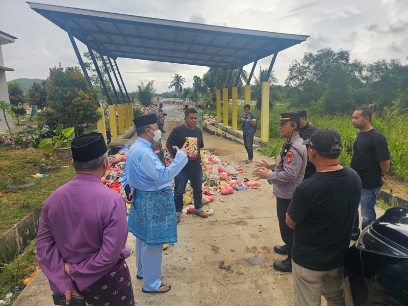 Kapolsek Meral Iptu Adi Chandra mendampingi Pj Bupati Karimun Ansar Ahmad meninjau proses pembersihan TPA Sememal, Sabtu, 11 Oktober 2024.