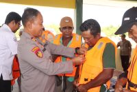 Kasat Polairud Polres Karimun IPTu Sarianto memakaikan secara simbolis life jacket kepadanelayan. Foto: istimewa