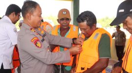 Kasat Polairud Polres Karimun IPTu Sarianto memakaikan secara simbolis life jacket kepadanelayan. Foto: istimewa