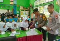 Wakapolres Karimun Kompol Herie Pramono membagikan makan siang gratis kepada siswa SDN 011 Tebing. Foto: Dokumen Polsek Tebing
